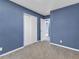 Bedroom with plush carpet, blue walls and closet at 1017 E Club Blvd, Durham, NC 27704