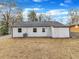 Rear exterior shows white siding and a new roof, complemented by an open grassy area at 1017 E Club Blvd, Durham, NC 27704