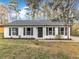 Charming single-story home featuring a white brick exterior, black shutters, and a well-manicured lawn at 1017 E Club Blvd, Durham, NC 27704