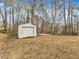 Detached garage with roll-up door, and an adjacent concrete pad on the tree-lined property at 1017 E Club Blvd, Durham, NC 27704