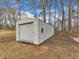 The property has a detached garage with a roll-up door, sitting among mature trees at 1017 E Club Blvd, Durham, NC 27704