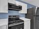Modern kitchen features stainless steel appliances and updated white cabinets at 1017 E Club Blvd, Durham, NC 27704