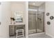 Nicely appointed bathroom featuring vanity with stool and tiled shower with glass door and window at 1040 Lippincott Rd, Durham, NC 27703