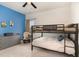 Charming bedroom features a bunk bed, blue accent wall, and dresser for ample storage at 1040 Lippincott Rd, Durham, NC 27703
