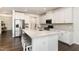 Bright kitchen with an island, seating, stainless steel appliances, and mosaic backsplash at 1040 Lippincott Rd, Durham, NC 27703