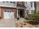 Charming home entrance features a brick facade, a single-car garage, and a quaint landscaped walkway at 106 Madison Square Ln, Cary, NC 27513