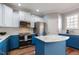 Stylish kitchen boasting a center island with marble countertops and two-toned cabinetry at 106 Madison Square Ln, Cary, NC 27513
