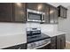 Close up of kitchen with stainless steel appliances, white backsplash, and dark cabinets at 108 Ripple Way # 319, Clayton, NC 27520