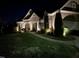 Striking nighttime view of a well-lit home highlighting architectural details and landscaping at 1101 Dovefield Ln, Youngsville, NC 27596