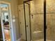 Modern tiled shower with glass door, a built-in seat, and decorative accent tiles at 1101 Dovefield Ln, Youngsville, NC 27596
