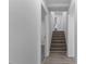Hallway with hardwood steps leading upstairs, a doorway, and neutral paint at 1101 Driftwood Dr Dr, Siler City, NC 27344