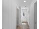 Hallway features white trim and walls, wood floors, closets, and a windowed door to the exterior at 1101 Driftwood Dr Dr, Siler City, NC 27344