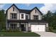 Inviting two-story home featuring vertical siding, stone accents, and an attached two-car garage at 115 Moonflower Ln # Homesite 259, Clayton, NC 27520