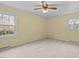 Light-filled bedroom with neutral carpet, a ceiling fan, and windows offering natural light and exterior views at 118 Tysor Cir, Graham, NC 27253