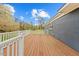 Wooden deck with white railings, offering a view of the private backyard with mature trees and shrubs at 118 Tysor Cir, Graham, NC 27253