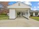 Daytime view of a charming single-story home featuring a connected carport, manicured lawn, and a welcoming front porch at 118 Tysor Cir, Graham, NC 27253
