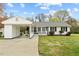 Daytime view of a charming single-story home featuring a connected carport, manicured lawn, and a welcoming front porch at 118 Tysor Cir, Graham, NC 27253