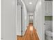 Bright hallway with hardwood floors, white trim, and access to multiple rooms and a half-bath at 118 Tysor Cir, Graham, NC 27253