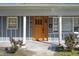 A solid wood front door with glass insets and blue-gray siding at 1213 Lincoln St, Durham, NC 27701