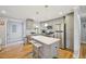 Bright kitchen with gray cabinetry, stainless appliances, an island with stool seating, and hardwood floors at 1213 Lincoln St, Durham, NC 27701