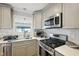 Well-lit kitchen featuring stainless steel appliances and gray cabinets at 1213 Lincoln St, Durham, NC 27701