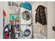 Laundry room with stacked washer and dryer, shelving, and ample storage space for cleaning supplies at 1213 Lincoln St, Durham, NC 27701