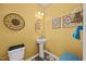 Charming yellow half-bathroom with pedestal sink and decorative accents at 1295 Kerr St, Burlington, NC 27215