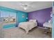 Bright bedroom with purple accent wall, ceiling fan, and a large window with neighborhood views at 1295 Kerr St, Burlington, NC 27215