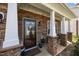 Charming front porch with stone accents, a decorative glass door, and well-maintained landscaping at 1295 Kerr St, Burlington, NC 27215