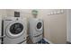 Bright laundry room with modern washer and dryer, plus shelving and hooks at 1295 Kerr St, Burlington, NC 27215