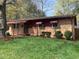 Charming brick home with a well-manicured lawn and inviting front porch with iron railing at 1314 Hearthside St, Durham, NC 27707