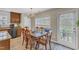Bright dining area with wooden table and chairs, modern chandelier, and ample natural light from the window at 1320 Rushing Creek Pkwy, Raleigh, NC 27610