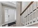 Welcoming foyer with hardwood floors, a staircase with white railings, and natural light streaming through the front door at 1320 Rushing Creek Pkwy, Raleigh, NC 27610