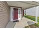 Charming front porch with dark red door, neutral siding, covered area, and a neatly kept front garden at 1320 Rushing Creek Pkwy, Raleigh, NC 27610
