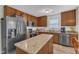 Well-equipped kitchen with granite countertops, stainless steel appliances, island, and ample cabinet space for storage at 1320 Rushing Creek Pkwy, Raleigh, NC 27610