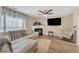 Bright and inviting living room with a fireplace, TV, ceiling fan, and natural light flowing through large windows at 1320 Rushing Creek Pkwy, Raleigh, NC 27610