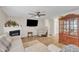 Living room with TV, fireplace, ceiling fan, and wood floors, providing a comfortable and stylish space at 1320 Rushing Creek Pkwy, Raleigh, NC 27610