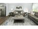Comfortable living room with a gray sofa set, modern décor, gray ottoman, and a view of stainless steel appliances at 145 Sunny Acres Rd, Garner, NC 27603