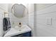 Charming powder room with shiplap walls, brass fixtures and a round mirror at 1624 Pantego Trl, Cary, NC 27519