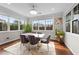 Sun-drenched dining room with large windows, hardwood floors, and a marble-topped table at 1624 Pantego Trl, Cary, NC 27519