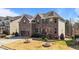Side view of a brick two-story home with manicured landscaping and a two-car garage at 1624 Pantego Trl, Cary, NC 27519