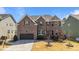 Beautiful brick two-story home with manicured landscaping and a two-car garage on a sunny day at 1624 Pantego Trl, Cary, NC 27519