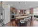 Kitchen featuring an island with seating, stainless steel appliances, and dark wood cabinetry at 1624 Pantego Trl, Cary, NC 27519
