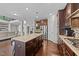 Open concept kitchen with a large island, dark cabinetry, and stainless steel appliances overlooking the living area at 1624 Pantego Trl, Cary, NC 27519