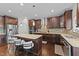 A stylish kitchen features dark wood cabinets, stainless steel appliances, a large island, and modern pendant lighting at 1624 Pantego Trl, Cary, NC 27519