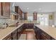 Gourmet kitchen featuring sleek countertops, stainless steel appliances, a stylish backsplash, and dark wood cabinets at 1624 Pantego Trl, Cary, NC 27519
