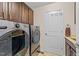 Functional laundry room with modern washer and dryer units and built-in cabinetry at 1624 Pantego Trl, Cary, NC 27519