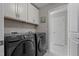 Laundry room featuring washer and dryer units and overhead cabinets at 1824 Longmont Dr, Wake Forest, NC 27587