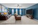 Living room with plush carpeting, ceiling fan, media center, and leather sofa beneath three window at 1824 Longmont Dr, Wake Forest, NC 27587