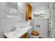 Functional bathroom with a single sink vanity, toilet, and built-in storage cabinet with a bright window at 200 N 9Th St, Erwin, NC 28339